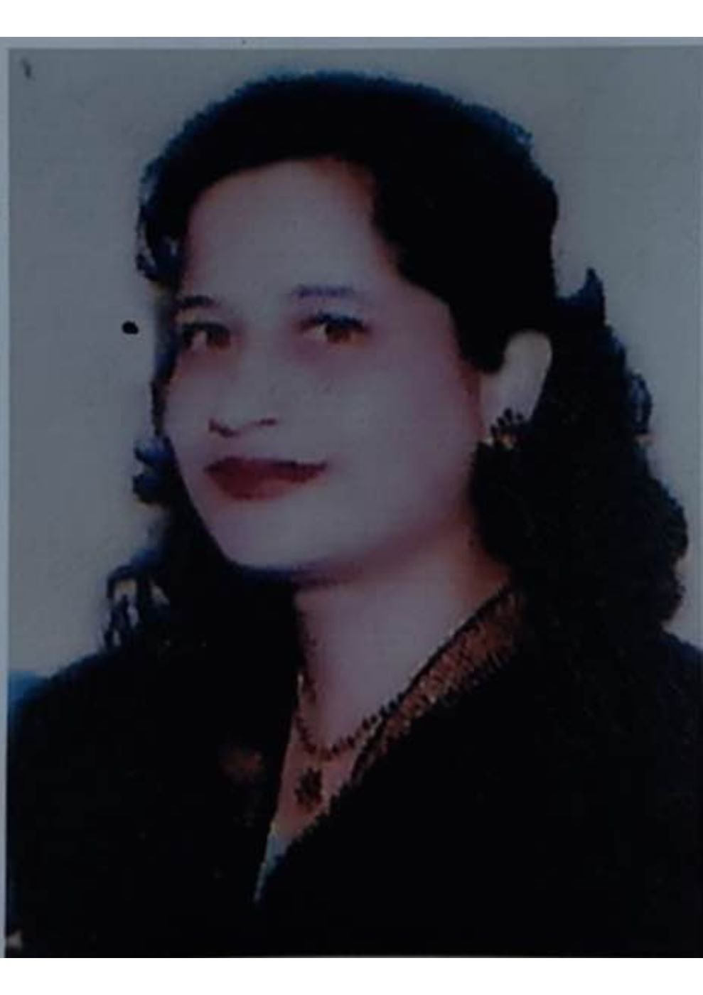 Portrait of Dr. Kapoor wearing traditional attire with academic books in background