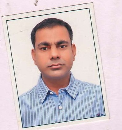 Portrait of Dr. Kapoor wearing traditional attire with academic books in background