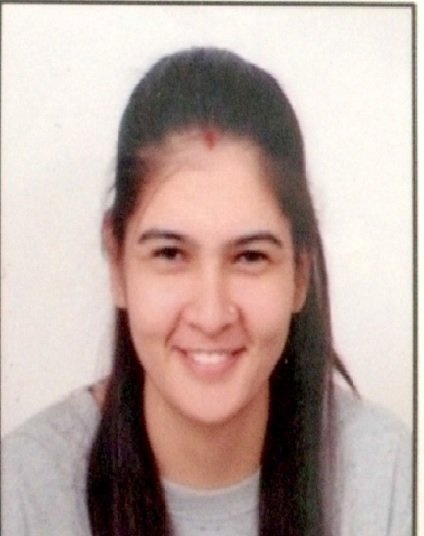 Portrait of Dr. Kapoor wearing traditional attire with academic books in background