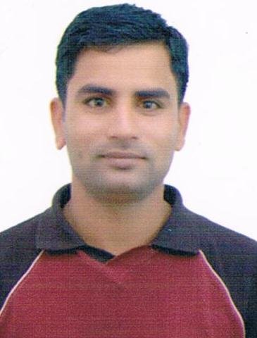 Portrait of Dr. Kapoor wearing traditional attire with academic books in background